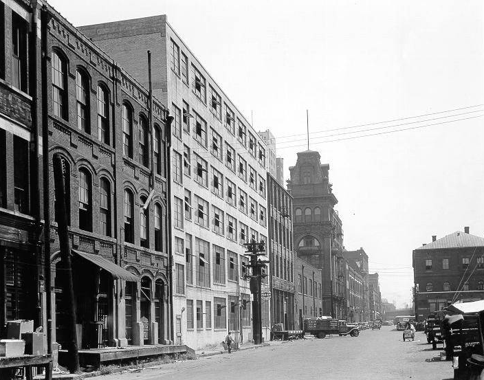 Early Morris Avenue (late 19th century), showing rows of buildings and a few vehicles on the road