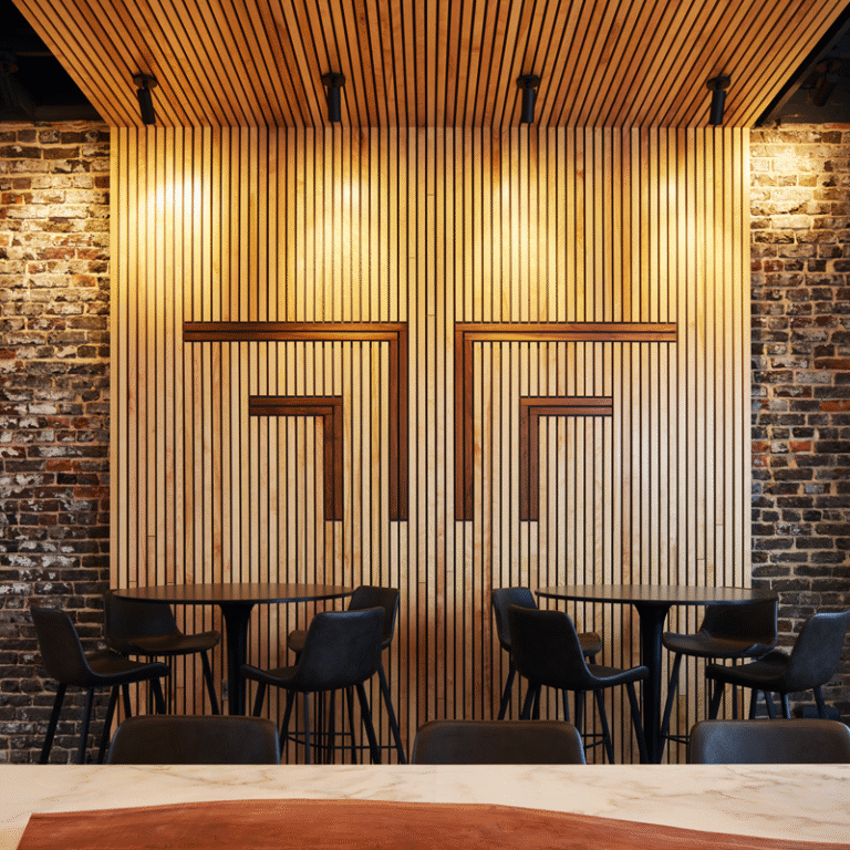 Fortif Law Partners, Morris Avenue, 2 black tables with chairs in front of wall with company logo on it