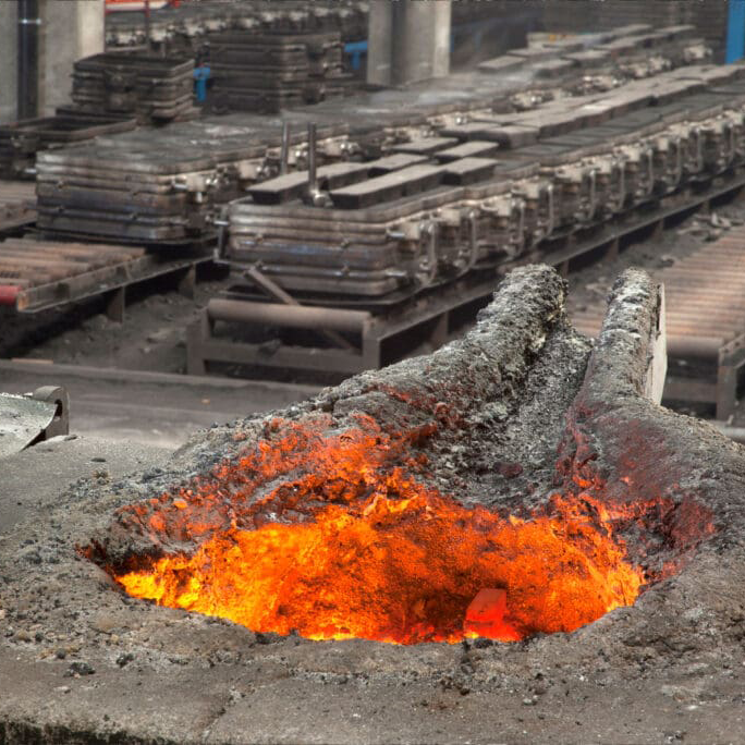 Foundry Supply Group, bright orange fire in foreground with several foundry supplies in background