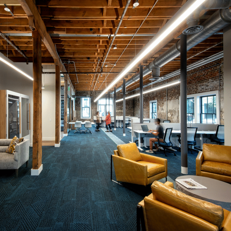 Harmony Venture Labs, Morris Avenue, work area with rows of desks and chairs. Rest area with chairs and table in foreground