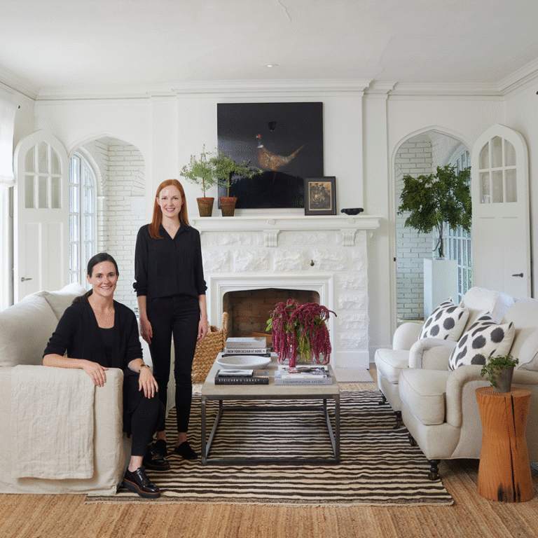 Still Johnson Interiors, white room with 2 women wearing black posing for the camera