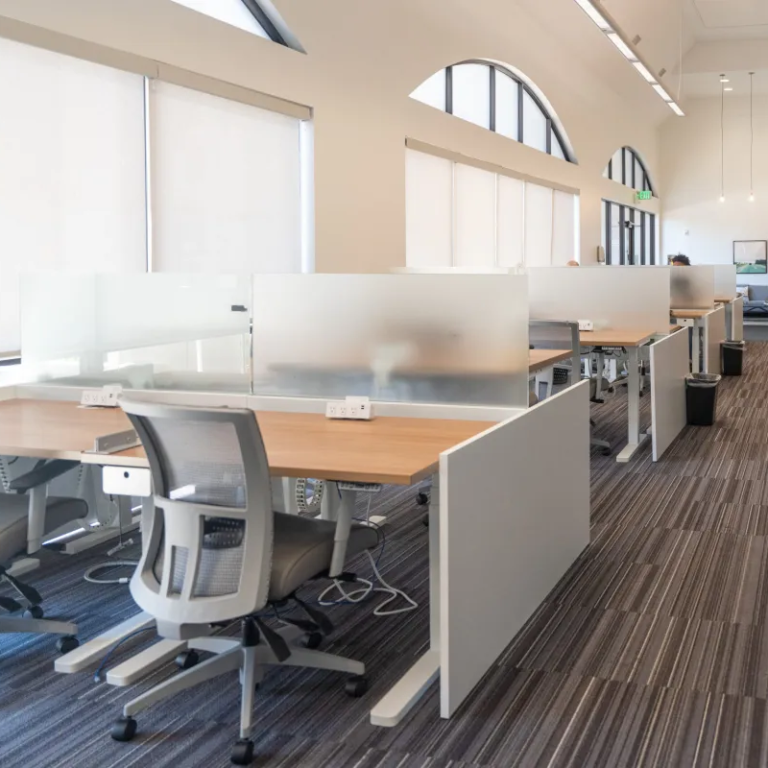 Tech Row, rows of desks and swivel chairs in white office with large windows