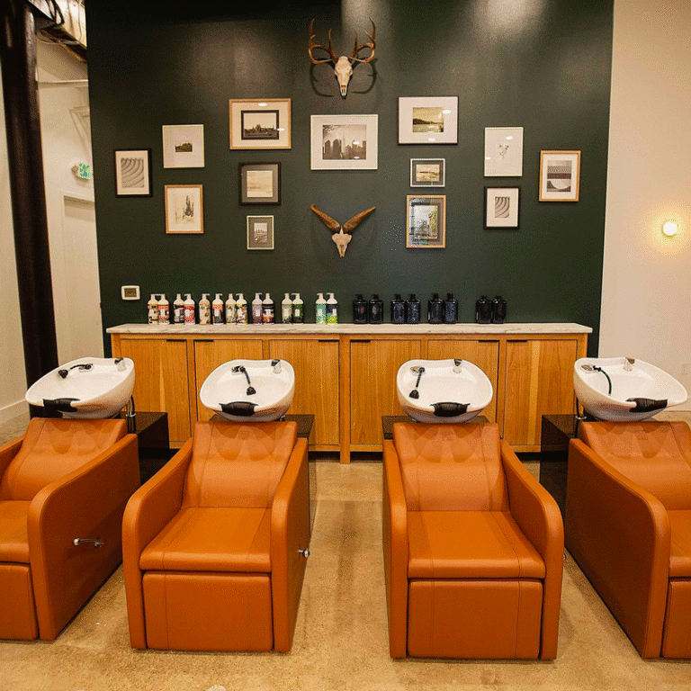 Well Salon, Morris Avenue, salon chairs with sinks behind them, dark green wall decorated with skulls and photos